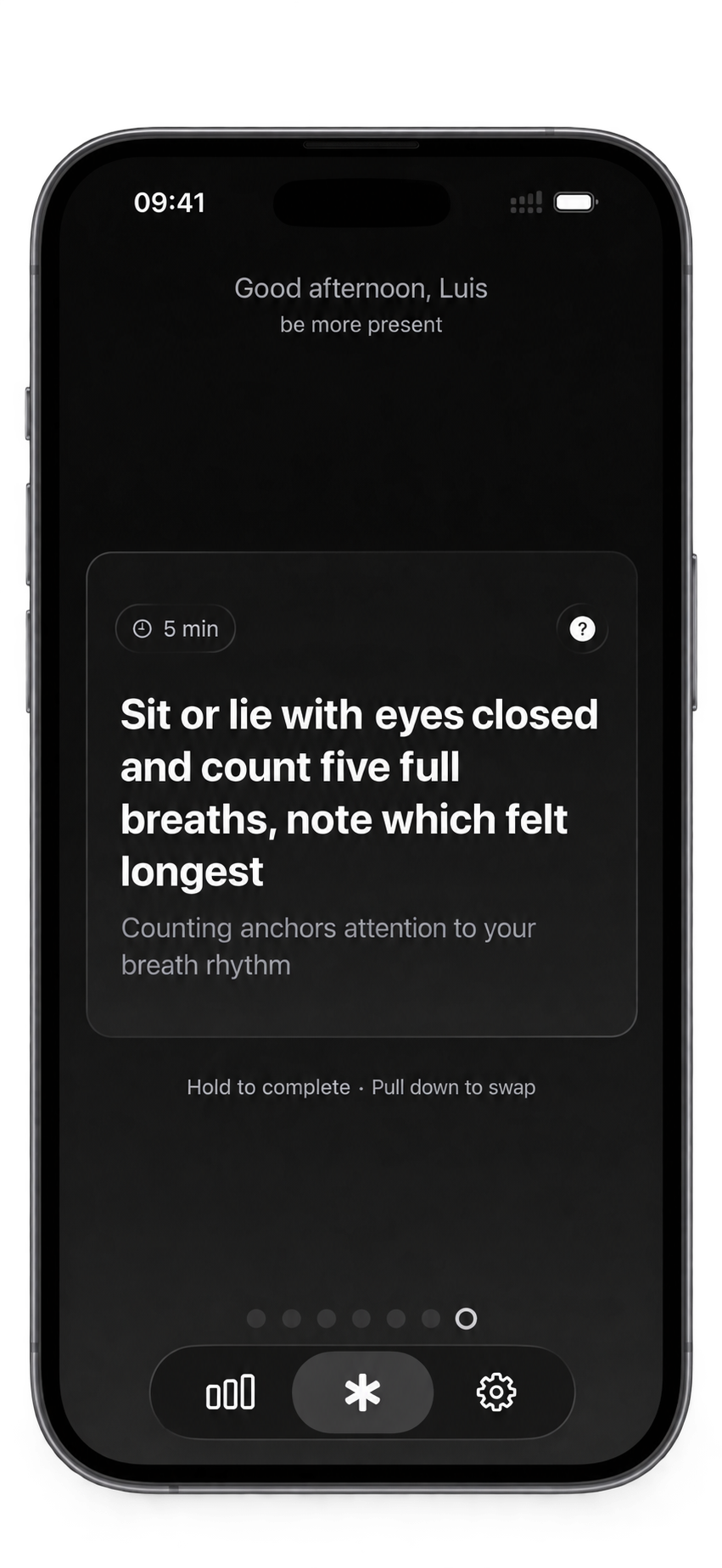 An iPhone showing the Today screen: “Good afternoon, Luis” above the goal “be more present”, then one card marked 5 min — sit or lie with eyes closed and count five full breaths, note which felt longest — with the line “Counting anchors attention to your breath rhythm” under it. Below the card: hold to complete, pull down to swap, and a row of seven dots for the week.